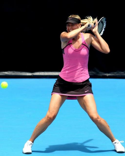 Maria Sharapova forehand follow through in a pink and black tennis outfit