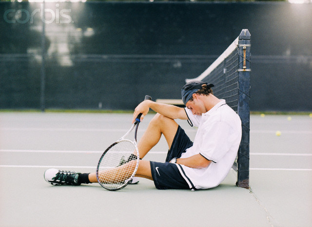 Tired Tennis Player Sitting on Court